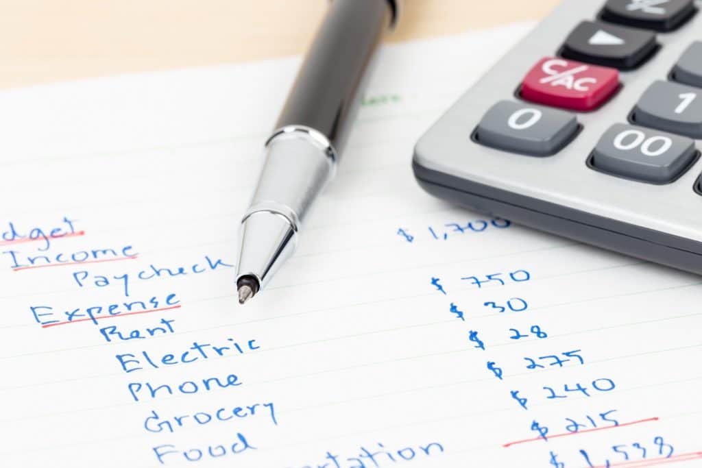 Household budgeting sheet with expenses and a calculator, representing tips to save money.