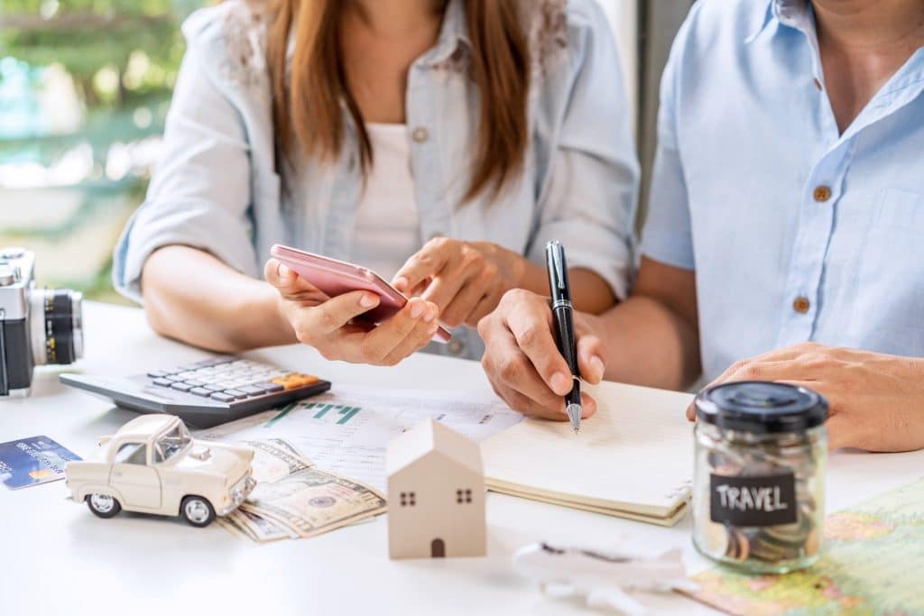 Couple planning their finances and travel savings together to travel on a budget