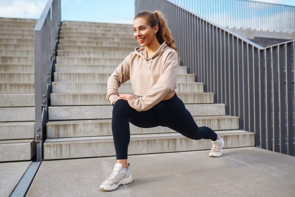 Woman doing morning yoga outdoors showing mindset in budget fitness tips