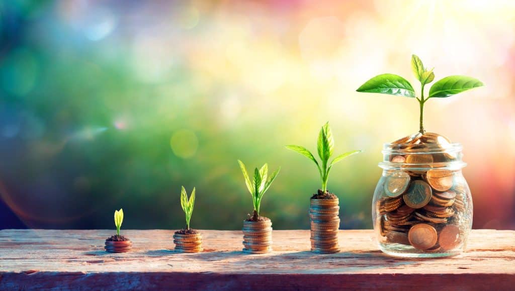 Daily financial habits of saving money with growing coins in jar which becomes fruitful as time passes by.