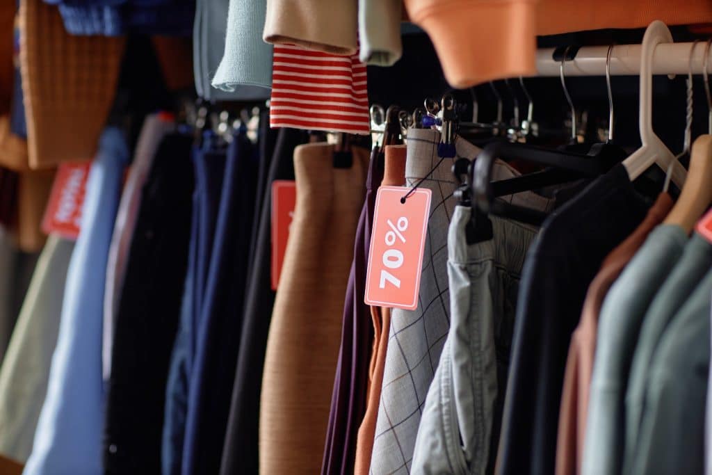 clothing rack with red 70% sale tags.