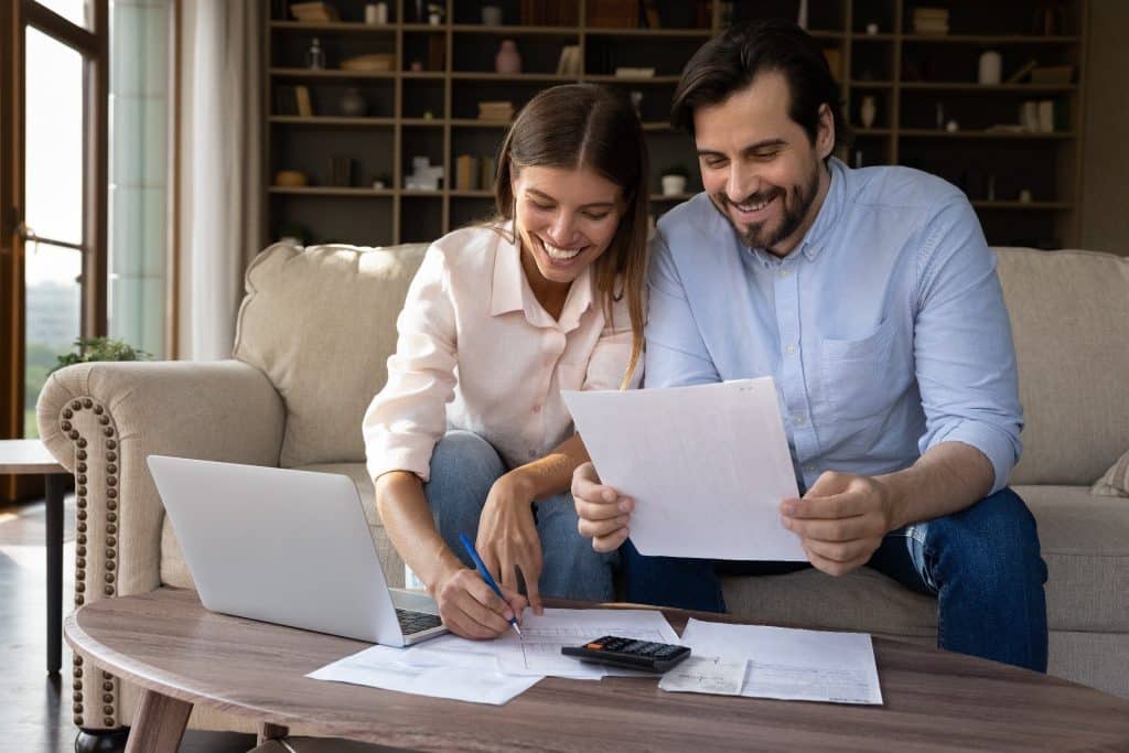 Smiling couple reviewing finances together, illustrating gratitude and money management.