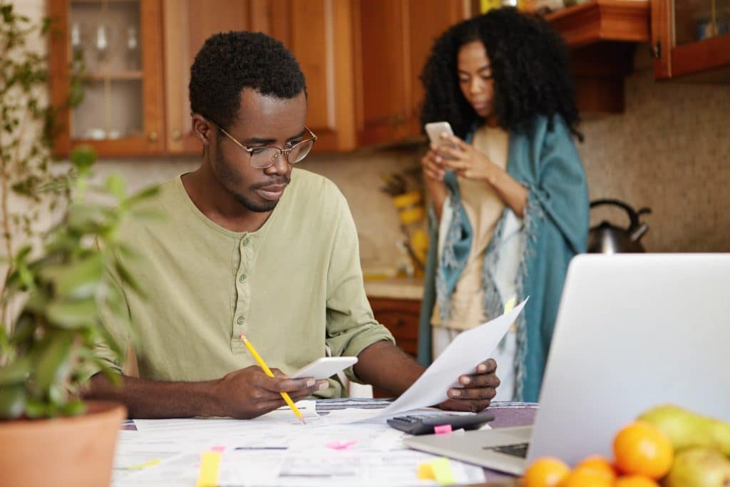 Man reviewing bills and finances at home while considering how to retire early.