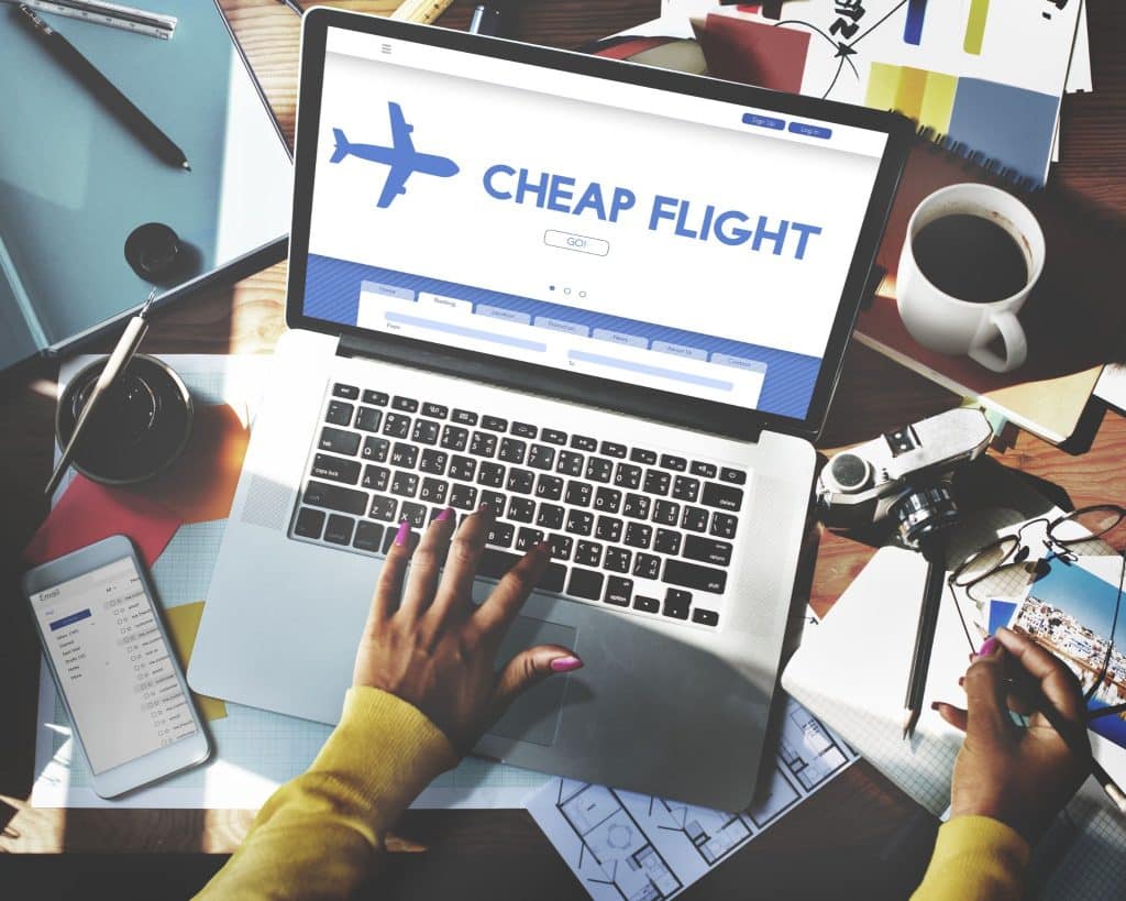 Laptop screen showing cheap flight booking – travel budget tips for booking flights at cheaper rates at right time.