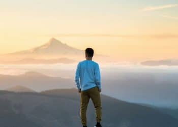man standing on top of mountain