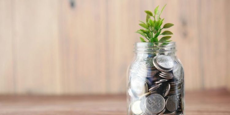 a glass jar filled with coins and a plant