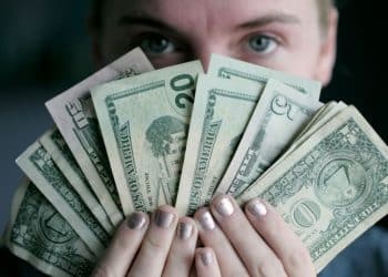 person holding fan of U.S. dollars banknote