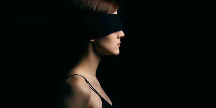 woman wearing black blindfold facing sideways