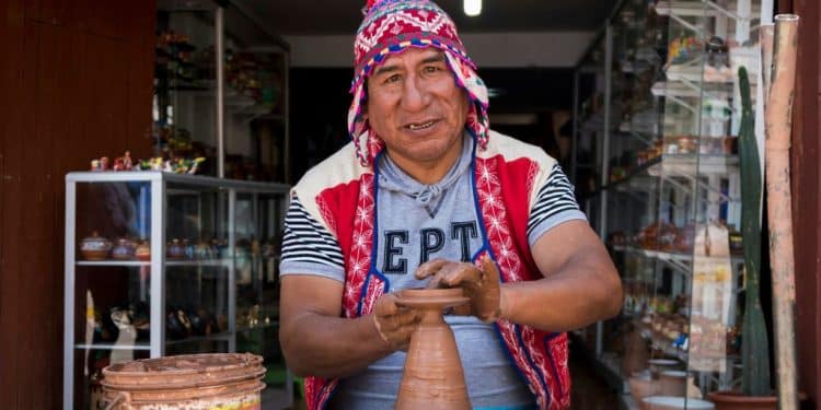 man making clay pot while sitting on chair