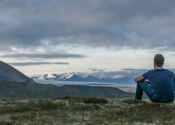 man sitting in the top of the mountain
