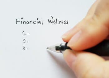 Handwriting a checklist under the title financial wellness, symbolizing personal steps toward financial wellness.