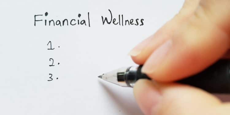 Handwriting a checklist under the title financial wellness, symbolizing personal steps toward financial wellness.