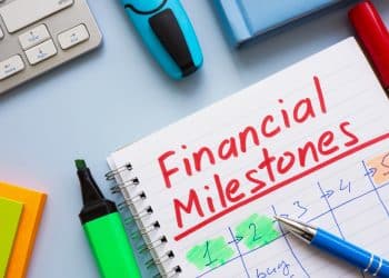 Notebook with the words financial milestones written, representing steps in setting financial goals