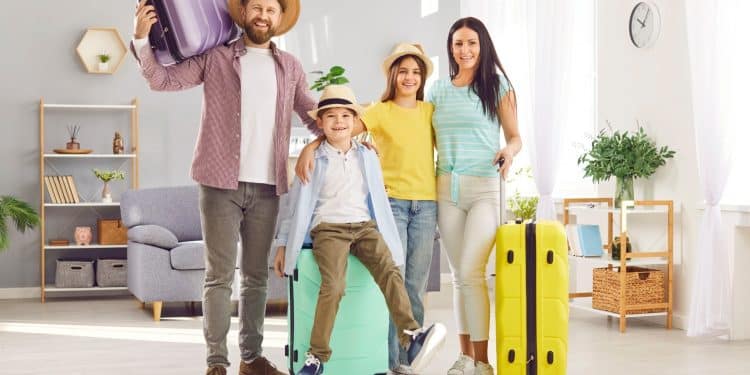 Family with kids happily packing suitcases at home, showing budget family travel tips in action before starting their trip.