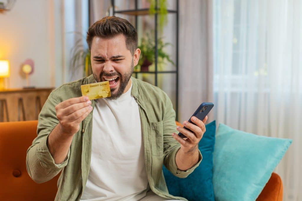 Man upset about credit card bill – understanding how to stop impulse buying online.
